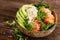 Hawaiian poke coconut bowl with grilled salmon fish, rice and avocado. Healthy food