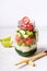 Hawaiian salmon poke salad in glass jar and bamboo chopsticks, selective focus