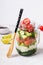 Hawaiian salmon poke salad in glass jar and bamboo fork, selective focus