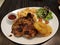 Hawaiian style grilled chicken chop with pineapple slices, vegetables and french fries.