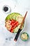 Hawaiian watermelon poke bowl with avocado, cucumber, mung bean sprouts and pickled ginger. Top view, overhead