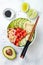 Hawaiian watermelon poke bowl with avocado, cucumber, mung bean sprouts and pickled ginger. Top view, overhead