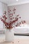 Hawthorn branches with red berries on wooden table in bedroom