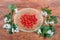 Hawthorn fruits on glass saucer among flowering branches hawthorn plant