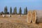 Hay bail harvesting in wonderful autumn farmers field landscape with hay stacks