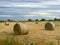 Hay bale rolled round straw in field background with cloudy sky and copy space