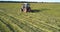 Hay balers intersect on vast field mowing grown grass