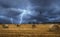 Hay bales on field during a lightning storm. Dark and stormy landscape