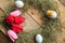 Hay frame, tulips and eggs on wooden background, top view.