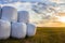 Hay preparation, rolls, hay reel, straw, bale, on a meadow on the grass. sunset