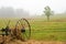 Hay rake in field in fog