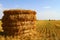 Hay roll on the field at autumn at harvesting time on the blue sky background