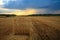 Hay-roll on meadow against sunset background