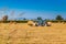 Hay round bales lift by farm tractor