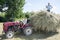 Hay. Summer day on the boy sitting on a tractor and another load