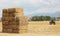 Hay tractor stacking hay bales on a big pile