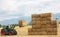 Hay tractor stacking hay bales on a big pile