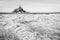 Hay windrows drying in the sun in front of the Mont Saint-Michel tidal island in Normandy, France