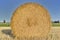 haybale in a field shooting from the front under blue sky