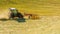 Haymaking on a hillside with rows of hay, a hay tedder and a hay-loader