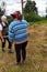 Haymaking season, two village women work in the field, preparing a wooden support for drying hay on it by driving it into the