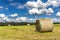 Haystack agriculture field landscape. Agriculture field hay stacks.Mown meadow with blue sky and clouds. Agricultural landscape in