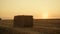 Haystack dry field after harvesting at golden sunset land. Rural landscape view.