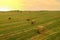 Haystack in field on sunset. Hay bale from residues grass. Hay stack for farm animals. Hay in rolls after round baler working in