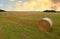 Haystack in field on sunset. Hay bale from residues grass. Hay stack for farm animals. Hay in rolls after round baler working in