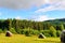 Haystack on the grassy field in summer. traditional carpathian rural landscape in mountains