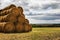 Haystack harvest agriculture farm field. Haystack rock on agricultural field. Farmland haystack view. Haystack field scene