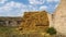 Haystack next to the barn. Stacked straw bales of hay. Square haystack under the open sky. Animal feed. Agricultural background.