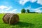 Haystack roll agriculture field landscape. Agriculture mown meadow with blue sky and clouds