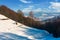 Haystack on snowy rural hillside near forest