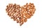 Hazelnut and almonds heap in heart shape on white background.