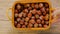 Hazelnut basket.Hand puts a basket of hazelnuts on a wooden table.Farmed organic ripe hazelnuts