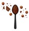 Hazelnut cocoa spread in a black spoon with scattered filbert kernels, chocolate pieces and chunks