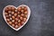 Hazelnut harvest. Nut in a heart plate on on black slate background. Hazelnut on the slate.