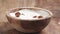 hazelnuts falling into yougurt cream in bowl on table in slow motion