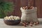 Hazelnuts, filbert in burlap sack and in brown bowl on rustic wooden table. heap or stack of hazelnuts. Hazelnut background, healt