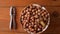 Hazelnuts in porcelain bowl on rustic wooden background. Raw fresh homegrowing nuts from house garden, weight loss diet