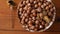 Hazelnuts in porcelain bowl on rustic wooden background. Raw fresh homegrowing nuts from house garden, weight loss diet