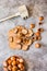 Hazelnuts in the shell in a small bowl and nutcracker. On a gray background