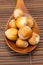 Hazelnuts on a wooden spoon on a bamboo mat