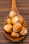 Hazelnuts on a wooden spoon on a bamboo mat