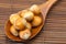 Hazelnuts on a wooden spoon on a bamboo mat