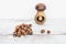 Hazelnuts on wooden table with one nut in mushroom-shaped nut-cracker