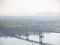 Hazy morning view on pedestrian Park Bridge, Trukhaniv island and left riverside of Dnieper river in Kyiv, Ukraine