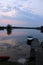 Hazy sunrise over lake reflection boat dock.