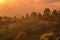 Hazy sunset over green village on the mountain slopes of Merbabu, Central Java, Indonesia.